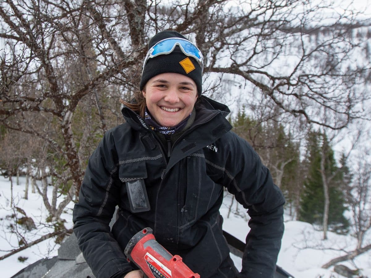Montører fra Vangen Harstad på takbytte ved en hytte i skogen.
